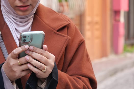 Individual engages with smartphone on a lively urban street with vibrant colors.