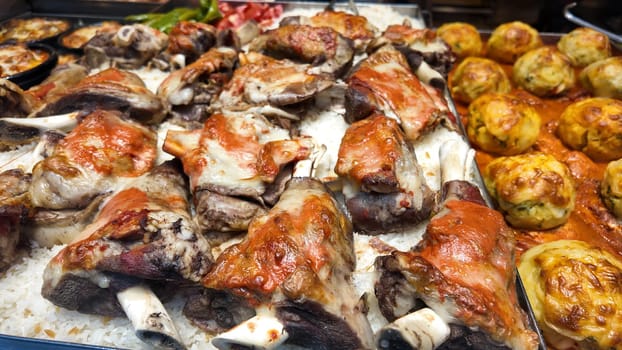 Tasty grilled meat with savory sauce placed alongside rice and pastries.
