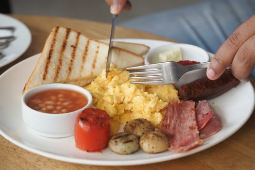 Breakfast includes scrambled eggs, toast, and various sides served on a plate.