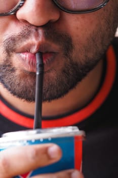 A person sipping a refreshing beverage using a straw, enjoying the moment.