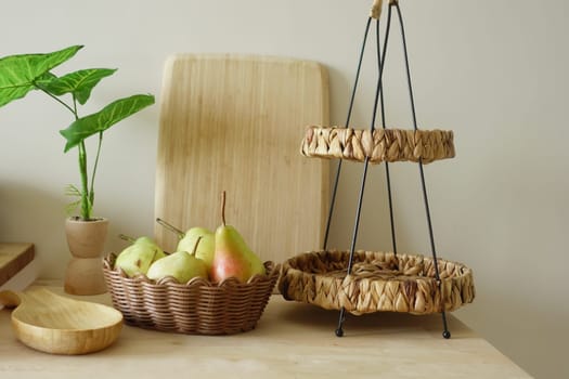 Fresh fruits in woven baskets complement a minimalist kitchen setting.