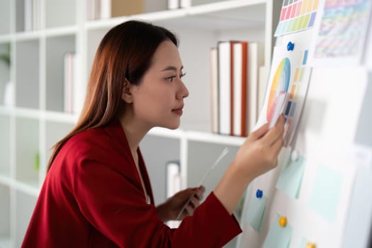 A female designer thoughtfully examines color samples on a board to inspire her creative process in a modern workspace.