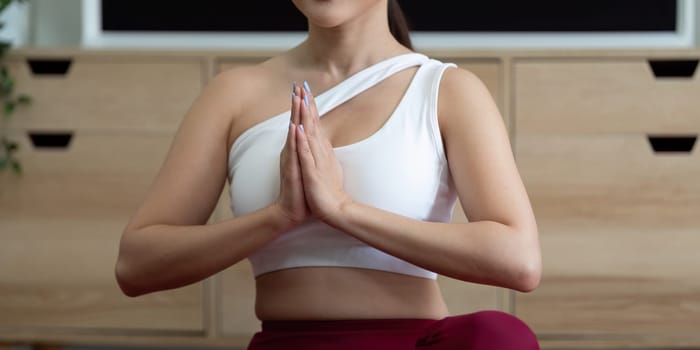 Capturing a moment of serenity, a woman in a yoga pose with palms together, symbolizing mindfulness and tranquility in her practice.