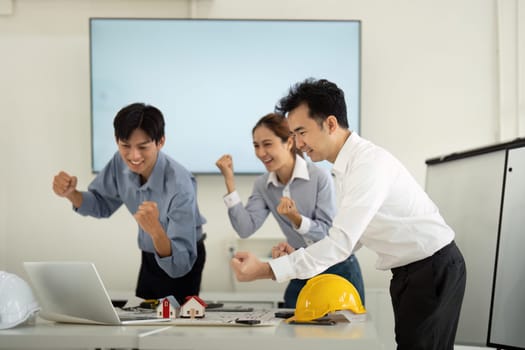 The team, brimming with excitement, plans their next steps in a construction project, showcasing their collaborative spirit and dedication to success.