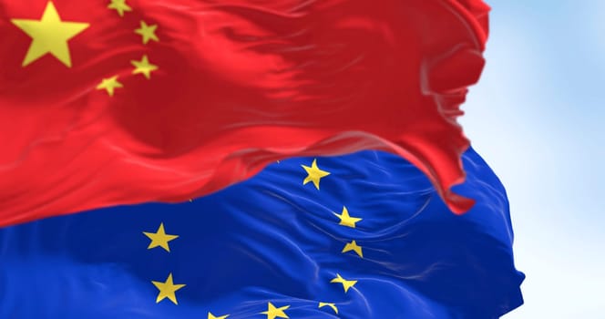 Flags of China and the European Union waving in the wind on a clear day. International relationship. 3d illustration render. Selective focus. Close-up