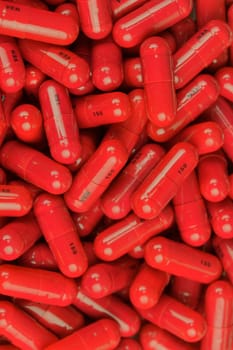 Red medicine capsules in a pile. Medication pills in capsules on a pile. The concept of medicine, medicine and healthful lifestyle.