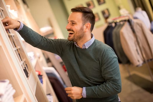 Handsome young man buying nektie in the store