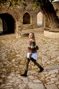 Pretty young woman walking in the autumn park on a sunny day