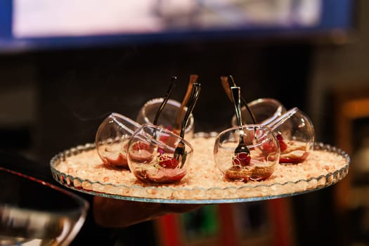 Elegant gourmet appetizers served in tilted glassware on a stylish crystal platter with decorative salts. Ideal for upscale dining, luxury events, and modern catering presentations.