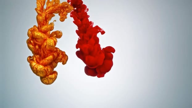 Golden and red ink flow effortlessly, mixing and swirling to form an enchanting abstract background. This liquid paint creates a captivating texture that draws the viewers eye.