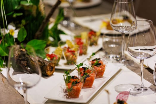 Exquisite gourmet salmon tartare appetizers elegantly presented in clear cups, garnished with black caviar and fresh microgreens, ideal for luxury events, cocktail parties, and high-end catering.