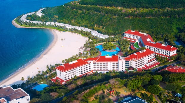 Luxury new modern hotel at sea with sandy beach in Hon Tre island in Nha Trang in Vietnam, top aerial view. A resort in Asia