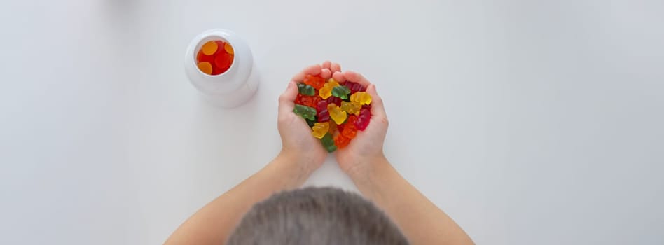 The boy eats jelly beans or takes vitamins.