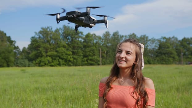 The girl watches the flight of the drone in the park