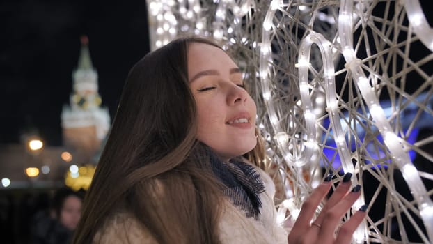 Happy girl on the background of Christmas garland in Moscow
