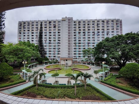 Hong Kong, China - April 06, 2024: Residents enjoy a peaceful garden area surrounded by tall buildings and vibrant foliage in central Hong Kong.