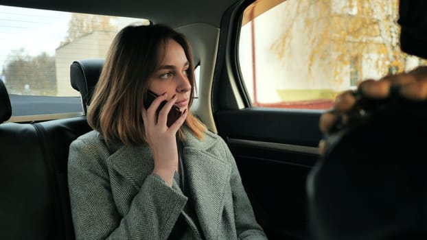 The girl in the car is talking on the phone