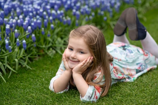 A cut girl smiles in a park with the muscaris