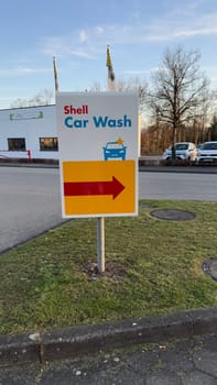 22.03.2025 Germany: Shell Gas Station Car Wash Sign With Directional Arrow. A Shell car wash sign standing on a lawn, directing vehicles with a bright arrow sign.