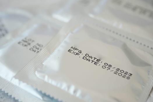 Close-up view of packaged condoms displaying important dates clearly.