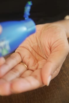 pouring hair oil on hand .