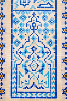 ancient old wall of Muslim mosque decorated with ceramic tiles with a traditional oriental Uzbek Islamic pattern in Uzbekistan