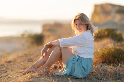 Tourist enjoying the sunset on a hill overlooking the sea