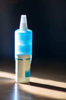 A blue spray bottle that has a white cap is placed on a table, showcasing its vibrant color and practical design for various uses