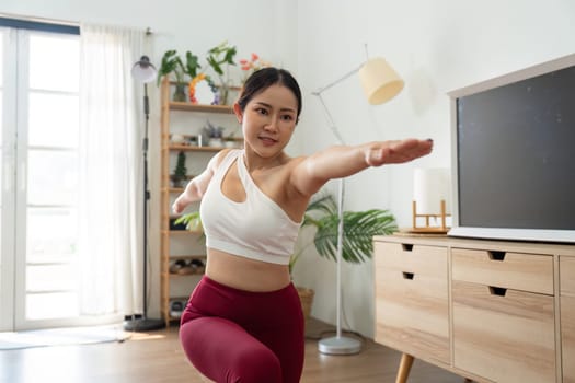In this image, a woman showcases her strength and poise while executing a warrior pose, embodying confidence and dedication to her yoga practice.