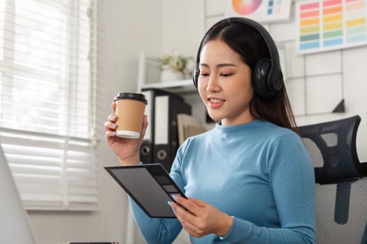 A designer assesses her digital notes while enjoying a cup of coffee, combining elements of creativity and comfort in her workspace for optimum productivity.