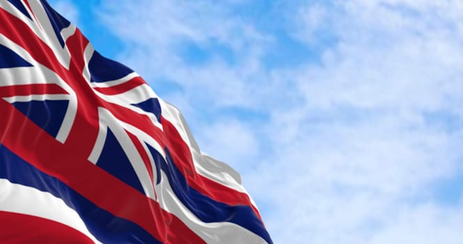 Close up of Hawaii state flag waving on a clear day. Eight horizontal stripes white, red, blue, Union Jack in canton. 3d illustration render. Rippled fabric. Selective focus