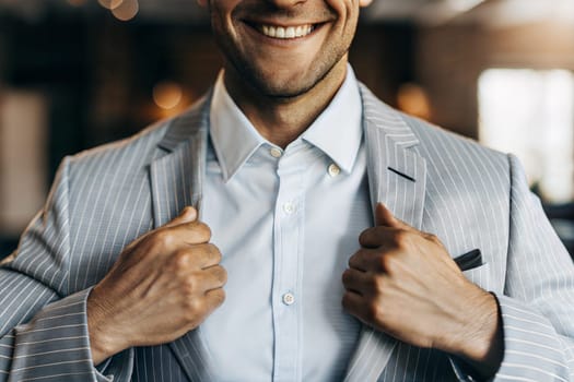 In a modern indoor space, a businessman in a striped suit smiles broadly while adjusting his jacket, exuding confidence and style. Generative AI.