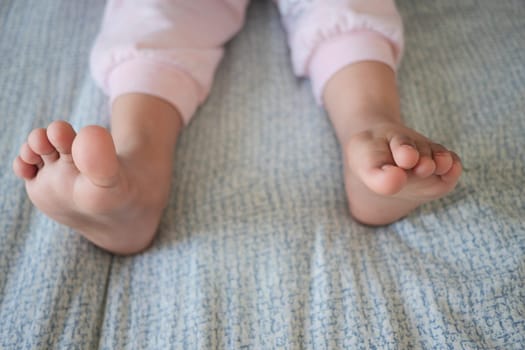 Little feet resting on bedding as children enjoy leisure time indoors.