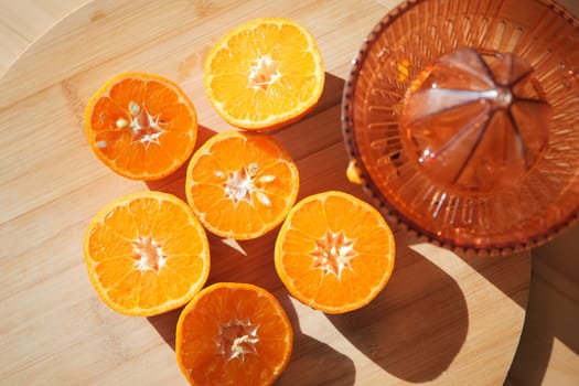 Vibrant orange halves arranged on a wooden surface ready for juicing.