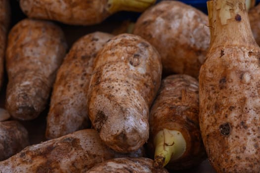 A variety of earthy tubers lie scattered on a market table, their rugged surfaces reflecting the light of a crisp autumn morning as vendors prepare for a lively day of sales.