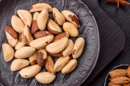 Brazil nut kernels in ceramic bowl on dark concrete background