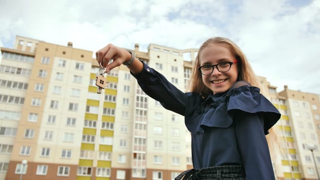 A young schoolgirl holds the keys to a new apartment