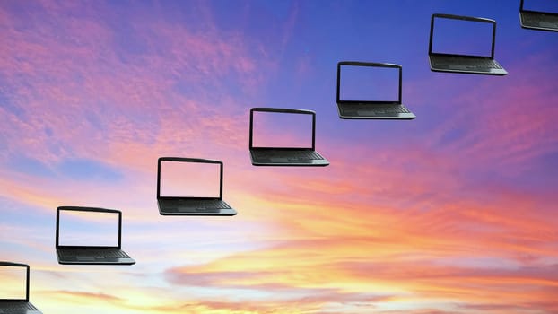 Laptops flying along the sunset  sky, concept cloudcomputing