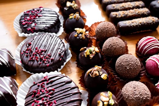 Assorted chocolate desserts with truffles, cookies, and toppings on display.