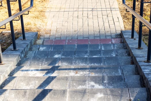 A welldefined set of stairs beautifully showcases a paved pathway basking under the warm glow of natural sunlight