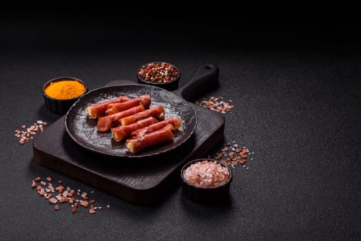 Cheese and meat, jamon or prosciutto rolled into a roll. Antipasti or delicacies for the festive table