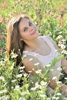 Happy 16 year old girl surrounded by a blooming field