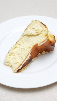 Close-up of a slice of San Sebastian cheesecake with caramel crust on a white plate