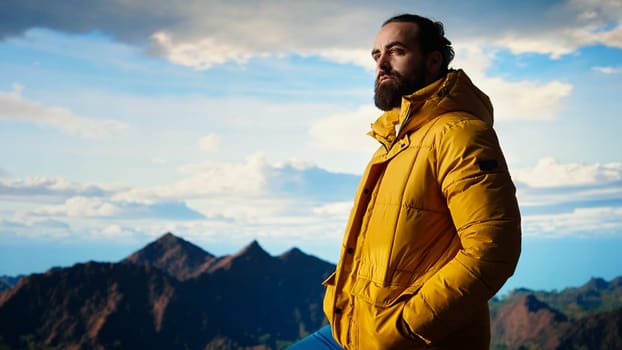Proud happy explorer feeling pleased climbing the mountain peak, enjoying mindfulness and determination. Young adult being passionate about the wilderness and the epic view. Camera A.