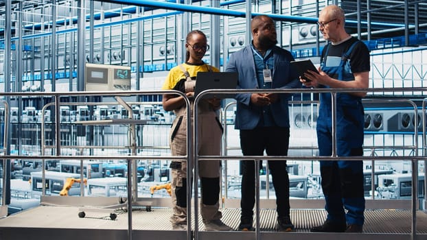Industry 4.0 photovoltaics plant manager overseeing work done by employees to maximize solar cells power generation. Solar panels smart factory supervisor coordinating technicians, camera A