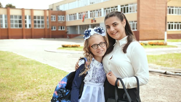 Two Russian schoolgirls sisters posing in festive clothes on the day of the beginning of the school year