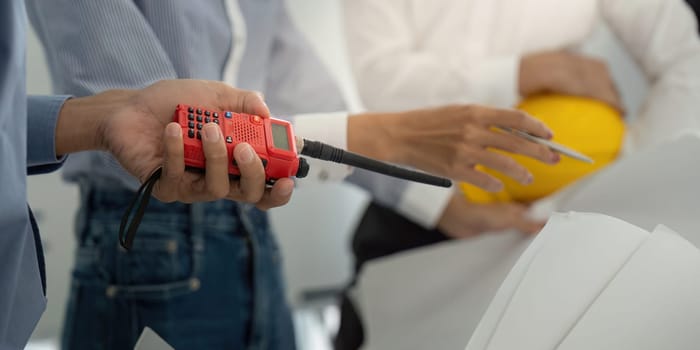Construction professionals utilize modern tools and effective communication devices to enhance their project discussions, focusing on precision and strategy in a collaborative environment.