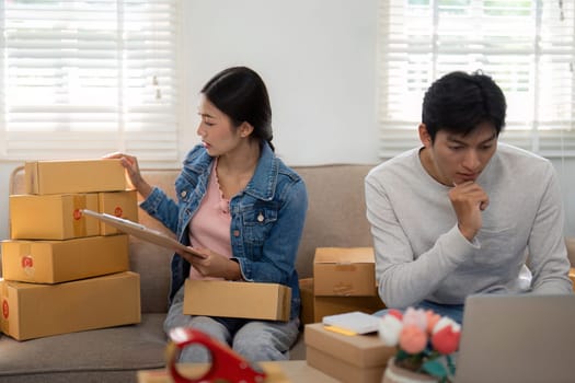 As they sit surrounded by their shipment, the young business partners maintain focus on their next steps, ensuring everything is organized for their entrepreneurial journey.
