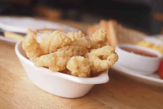 Enjoying crispy fried calamari with tangy dipping sauce at lunch.