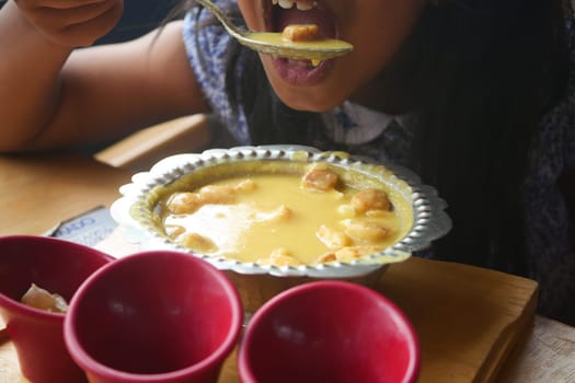 A person savors a rich dessert while seated at a cozy table.
